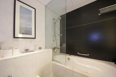 a bathroom with a tub and a glass shower at Partial Burjkhalifa View from Balcony in Dubai Mall-Studio King Bed in Dubai