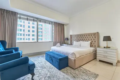 a bedroom with a large bed and a blue chair at Cozy 2bd in Dubai Marina in Dubai
