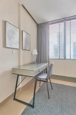 a desk with a chair in a room with a window at Cozy 2bd in Dubai Marina in Dubai