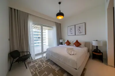 a bedroom with a bed and a large window at Homes Beyond I Modern 2BR Getaway with Beach Access in Dubai