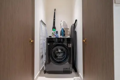 a washing machine in a room next to a door at Homes Beyond I Modern 2BR Getaway with Beach Access in Dubai
