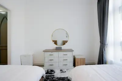 a bedroom with two beds and a mirror on a dresser at Souk Al Bahar Dubai Fountain and Burj Khalifa view from the Balcony, 2 mins walk to Dubai Mall by Norbu Holiday Homes in Dubai