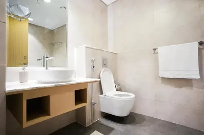 a bathroom with a white toilet and a sink at 5 Star Stay, Infinity Pool with Burj Khalifa Views in Dubai