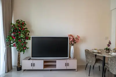 a flat screen tv sitting on a cabinet in a living room at Homes Beyond I 1BR Coastal Haven Walk to the Beach in Dubai