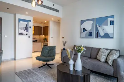 a living room with a couch and a table at Homes Beyond I 1BR Coastal Haven Walk to the Beach in Dubai