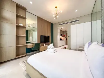 a bedroom with a large white bed and a desk at Stylish Studio in the Heart of Al Furjan 20AB4 in Dubai