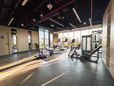a gym with several treadmills and elliptical machines at Stylish Studio in the Heart of Al Furjan 20AB4 in Dubai