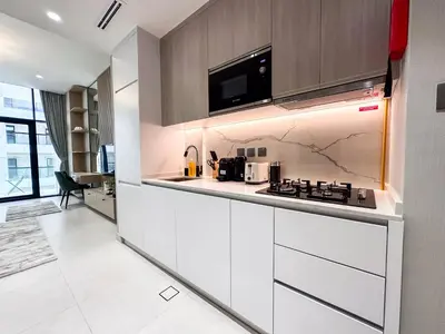 a kitchen with white cabinets and a stove at Stylish Studio in the Heart of Al Furjan 20AB4 in Dubai