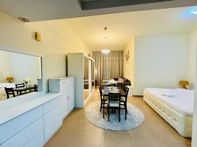 a bedroom with a bed and a table in a room at Premium Large Studio in Hamilton residency business bay Marasi Drive Dubai in Dubai