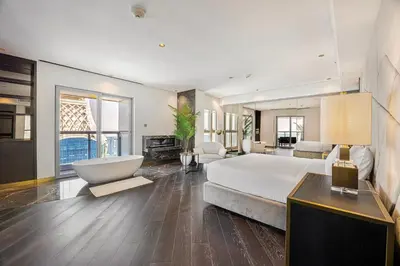 a large bedroom with a large bed and a tub at Daniels 3BR at Princess Tower With Full Palm Jumeirah View in Dubai
