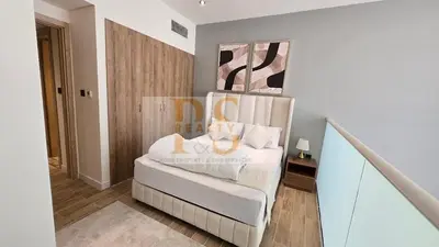 a bedroom with a bed with white sheets and pillows at 1 bed townhouse in Dubai