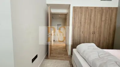 a bedroom with a bed and a wooden door at 1 bed townhouse in Dubai
