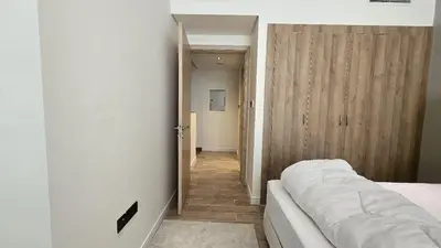 a bedroom with a white bed and a wooden door at 1 bed townhouse in Dubai