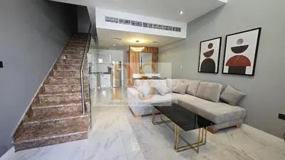 a living room with a couch and a staircase at 1 bed townhouse in Dubai