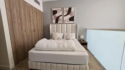 a bedroom with a bed with white sheets and pillows at 1 bed townhouse in Dubai