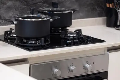 two pots on top of a stove in a kitchen at New 1BR APT Business Bay w Burj View in Dubai
