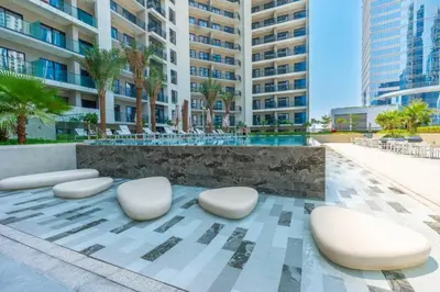 a group of white chairs and a building at Keyrock Living - Lakeview Retreat in Business Bay in Dubai