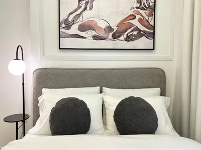 a bedroom with a bed with pillows and a painting at Exclusive Lakeview Haven - Zada Tower by Keyrock Living in Dubai