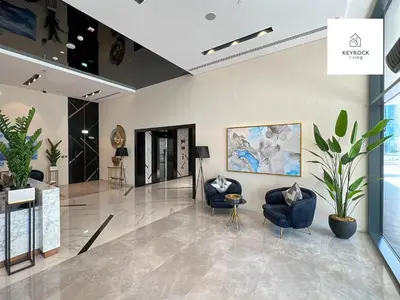 a lobby with two chairs and a painting on the wall at Exclusive Lakeview Haven - Zada Tower by Keyrock Living in Dubai