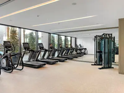 a gym with a row of treadmills and machines at 1BR Palace Residences, City View in Dubai