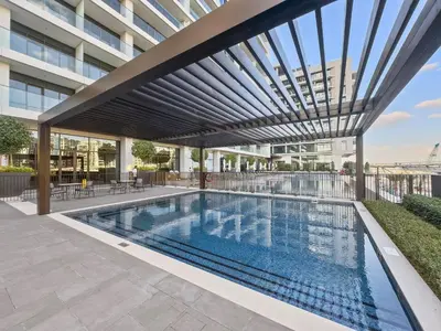 a swimming pool with awning on a building at 1BR Palace Residences, City View in Dubai