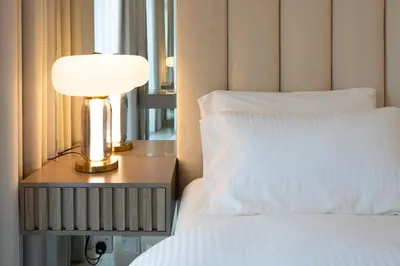 a bedroom with a bed and a lamp on a night stand at Keyrock Living - Exclusive Luxury at Aykon Tower in Dubai
