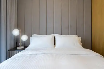 a bed with white sheets and pillows at Keyrock Living - Exclusive Luxury at Aykon Tower in Dubai