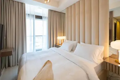 a bedroom with a large white bed and a window at Keyrock Living - Exclusive Luxury at Aykon Tower in Dubai