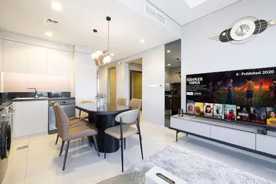 a kitchen and dining room with a table and a tv at Modern 3-Bedroom Apartment with Breathtaking City Views in Dubai