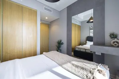 a small bedroom with a bed and a mirror at Modern 3-Bedroom Apartment with Breathtaking City Views in Dubai