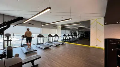 a person is walking on treadles in a gym at Modern 3-Bedroom Apartment with Breathtaking City Views in Dubai