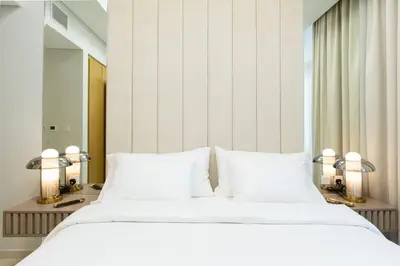 a bedroom with a white bed and a mirror at Keyrock Aykon Tower, Business Bay - Pool & Gym in Dubai