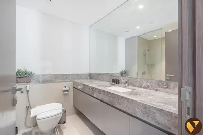 a bathroom with a toilet and a sink and a mirror at Vogue Downtown Act One near Burj Khalifa and Dubai Mall, Two Bedroom Apartment with Balcony and City Skyline View, Access to All Amenities in Dubai