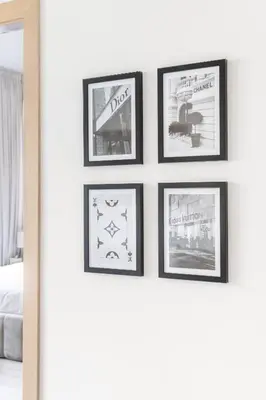 a group of framed pictures on a wall in a bedroom at Serene 2BRplus1 Haven in Oakley JVC - 5star Amenities in Dubai