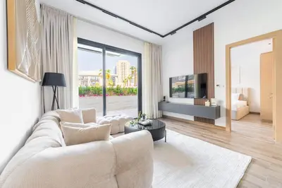 a living room with a white couch and a tv at Serene 2BRplus1 Haven in Oakley JVC - 5star Amenities in Dubai