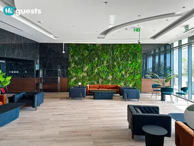 a lobby with a green wall with a couch and chairs at HiGuests - Stylish 1BR Retreat with Modern Interiors in Dubai in Dubai