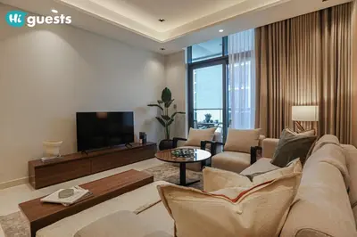 a living room with a couch and a flat screen tv at HiGuests - Stylish 1BR Retreat with Modern Interiors in Dubai in Dubai