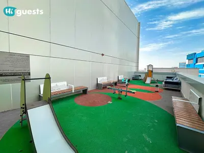 a building with a playground with benches and a slide at HiGuests - Stylish 1BR Retreat with Modern Interiors in Dubai in Dubai