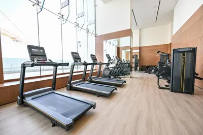 a row of treadmills in a gym with large windows at Pure Voyage JVC in Dubai
