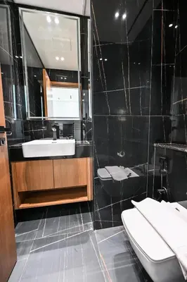 a bathroom with a sink and two toilets at Pure Voyage JVC in Dubai