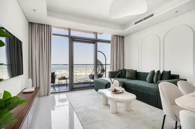 a living room with a green couch and a table at UrbanStays Dubai - Paramount Midtown in Dubai