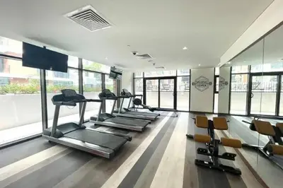 a gym with treadmills and chairs in a room with windows at 016 - Dubai Hills in Dubai