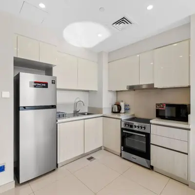 a kitchen with white cabinets and a stainless steel refrigerator at 016 - Dubai Hills in Dubai