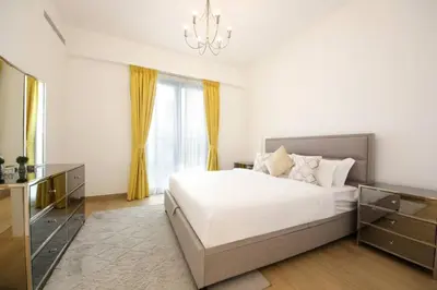 a bedroom with a large bed and a chandelier at 015 - Le Pont 1 in Dubai