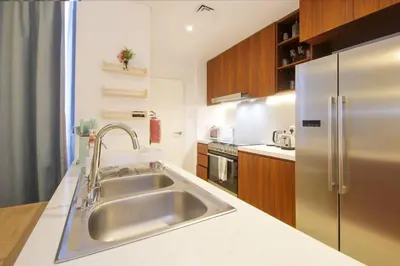 a kitchen with a sink and a stainless steel refrigerator at 015 - Le Pont 1 in Dubai