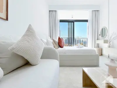 a white living room with a white couch and a window at Studio Charm at Legacy Ideal Arjan Stay in Dubai