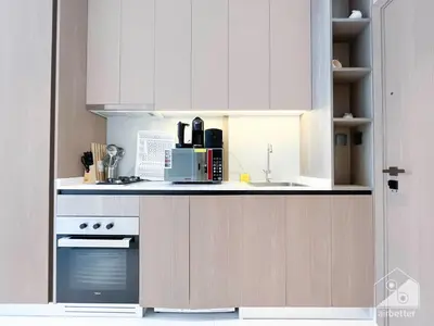 a kitchen with white cabinets and a stove top oven at Studio Charm at Legacy Ideal Arjan Stay in Dubai