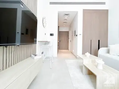 a living room with a large tv and a couch at Studio Charm at Legacy Ideal Arjan Stay in Dubai