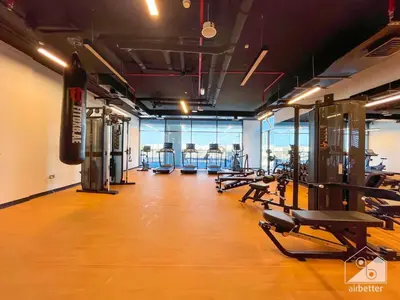 a gym with several treadmills and machines in a room at Studio Charm at Legacy Ideal Arjan Stay in Dubai