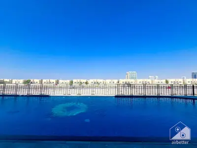 a large swimming pool with a city in the background at Luxurious Studio in Arjan With Balcony & Views in Dubai
